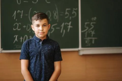 Cute boy stand in the classroom background of blackboard. Education. Elementary Stock Photos