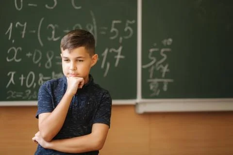 Cute boy stand in the classroom background of blackboard. Education. Elementary Stock Photos