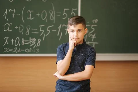 Cute boy stand in the classroom background of blackboard. Education. Elementary Stock Photos