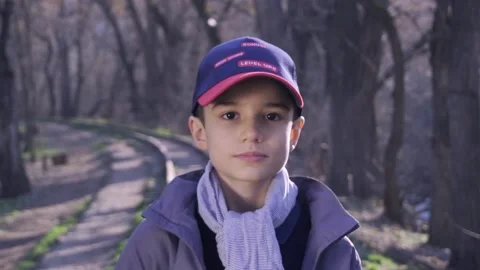 Cute boy is standing on railway in forest with a book in his hand 库存影片 172584845