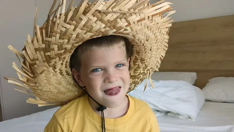 Cute boy in straw hat make face. Preschool child show tongue. Stock-Footage 256141817