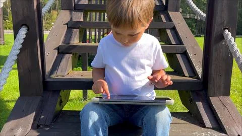 Cute boy studing on digital tablet computer. Development application for little Stock Photos