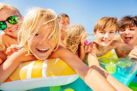 Cute boy taking selfie with friends on the beach Stock Photos
