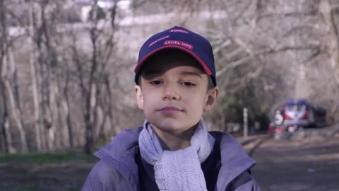 Cute boy walking on railway in forest with a book in his hand 库存影片 172584820