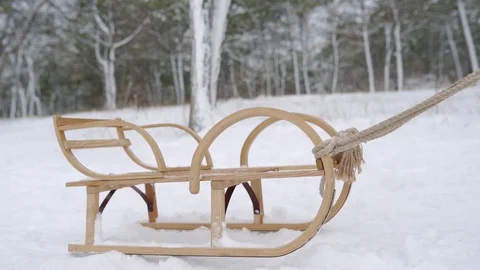 Cute boy in warm clothing pulling wooden sled on snowy winter day. Little guy Stock Footage 119253441