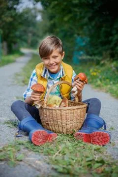 Cute boy with wild mushroom found in the forest Fotos Stock