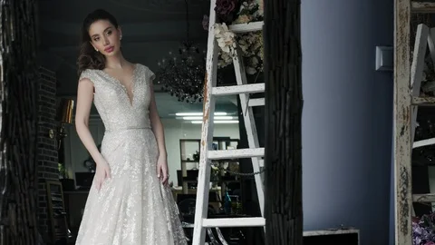 Cute bride with long dark ponytail stands in lacy dress Stock Footage 108103554