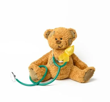 Cute brown teddy bear with a patch, a silk yellow ribbon in the shape of a lo Stock Photos