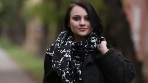 Cute brunette in a black coat, posing on a city street Vídeo Stock 67973813