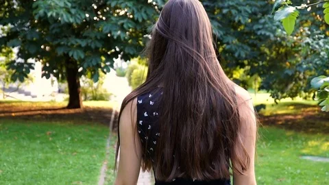 Cute brunette is walking in the park. slow motion Stock Footage 80398995