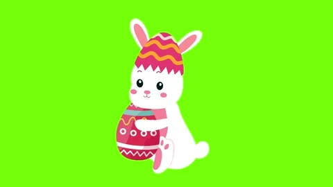 Cute bunny wearing a patterned egg hat on green screen Stock Footage 329585381