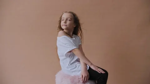 Cute casual girl posing while wind blow long hair. Children's photo session on a Video stock 146746521