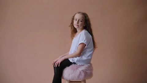 Cute casual girl posing while wind blow long hair. Children's photo session on a Video stock 146838370