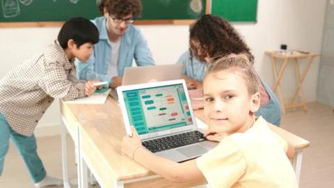 Cute caucasian boy coding program and looking at camera in STEM class. Pedagogy. Foto stock