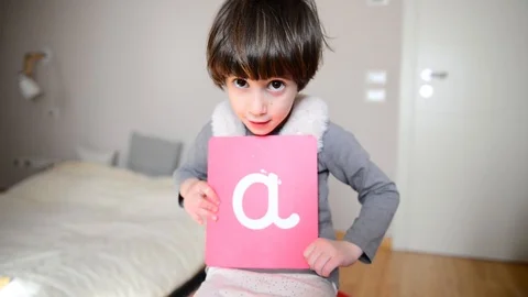 Cute caucasian child learns to write showing Montessori letters 스톡 동영상 124946378
