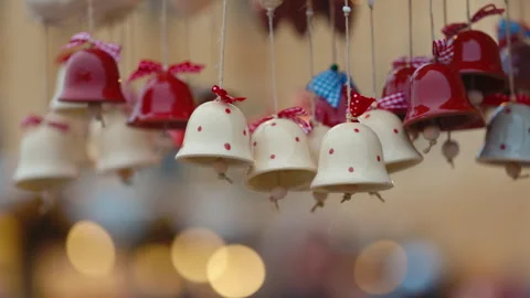 Cute ceramic bells with checkered bows hang on display of stall at winter fair Stock Footage 316767511