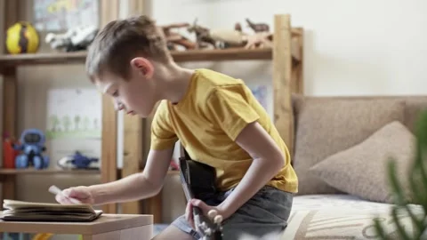A cute cheerful boy is playing the ukulele in the children's room Stock Footage 277942773