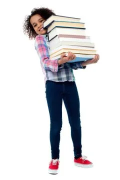 Cute cheerful child carrying stack of books Stock Photos