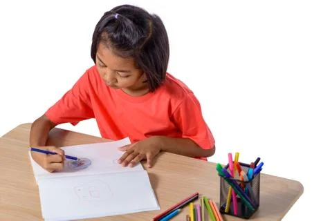 Cute cheerful child drawing using color pencil while sitting at table isolate Stock Photos