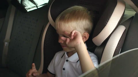 Cute cheerful kid is having fun in the kids car seat during the summer journey. Stock Footage 114977325