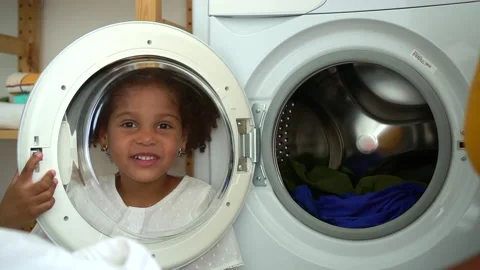 Cute child behind washing machine glass talk to mom Spbd. mom and daughter on Stock Footage 141840409