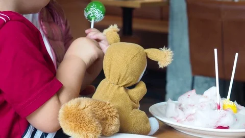 Cute child bites big candy lollipop Stock Footage 118598059