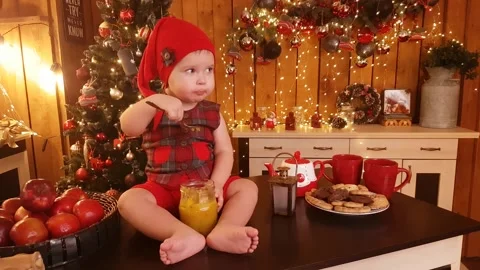 Cute child boy with bare feet, sits on the table and eats jam Stock Footage 234125239