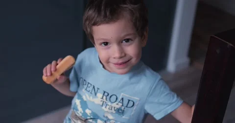 Cute child boy with cookie in hand smile look straight to camera. Handsome Stock Footage 237474583