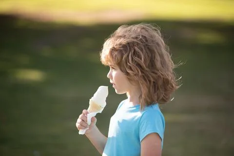 Cute child boy eating ice cream. Close up caucasian kids face. Closeup head of Stock Photos