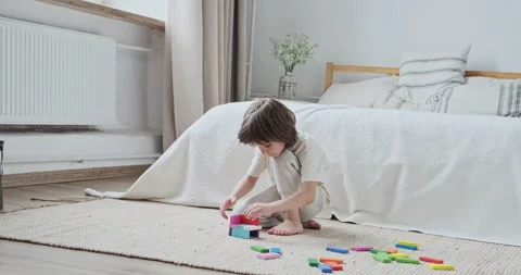 Cute child boy focused constructing architecture with colorful wooden brick Stock Footage 164968763