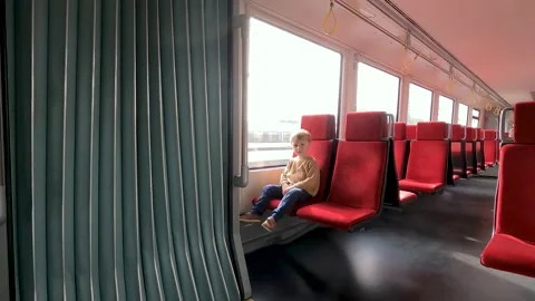 Cute child, boy, sitting inside the train, waiting for departure, looking at the Stock Footage 220335989