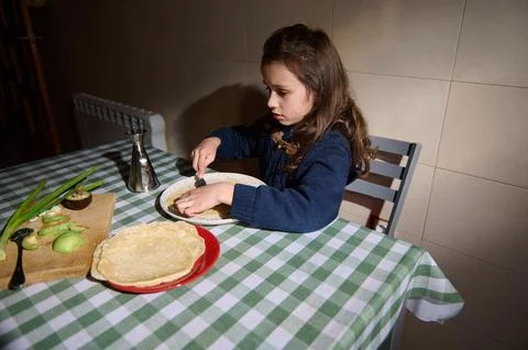 Cute child breakfasting with flatbreads with avocado and olive oil Foto stock