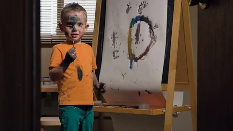 Cute child (Caucasian boy) is having fun, painting in his room. Видео 129721188