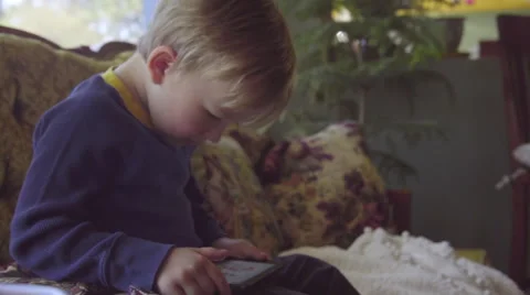 Cute child on couch with phone Stock Footage 64404005