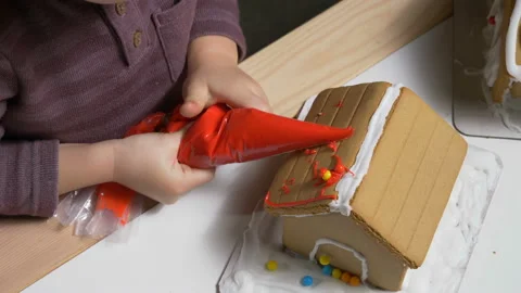 Cute child decorating gingerbread cookie house, closeup colorful festive candies Stock Footage 122563359