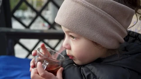 Cute Child Drinking Tea from a Clear Glass, Outdoors Stock Footage 307191291