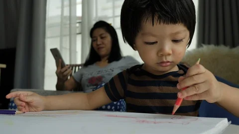 Cute child learn drawing in home with mom playing mobile phone Stock Footage 109496784