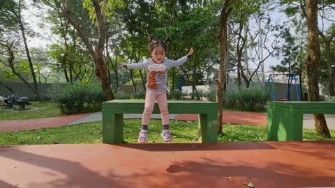 Cute child learning to jump from a tall bench Stock Footage 159440458