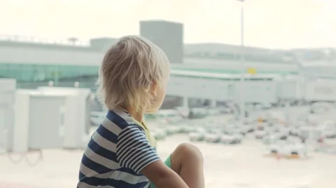 Cute child looking out the window in airport and pointing at ground staff Stock-Footage 65886557