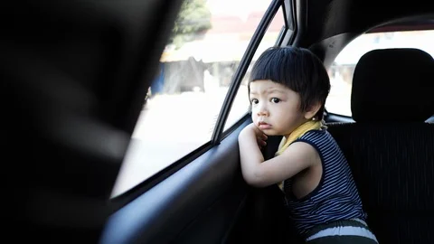 Cute child looking through window inside car Stock Footage 94176114
