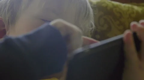 Cute child playfully uses a large smart phone Stock Footage 64644278
