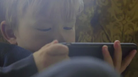 Cute child playfully uses a large cell phone Stock Footage 64644518