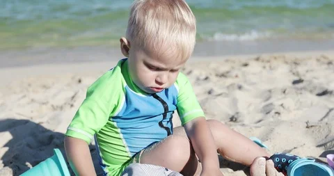 A cute child is playing on the beach with sand. Stock Footage 103281215