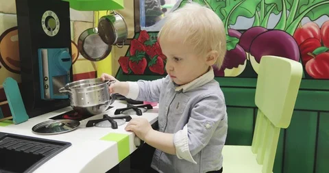 A cute child is playing in the kitchen with pots. Stock Footage 86084624