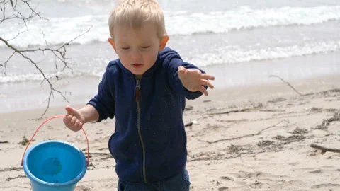 A cute child   is playing with sand on a beach Vídeo Stock 107117454
