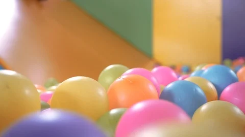 Cute child playing slide in plastic dry pool with colorful balls at playground. Stock Footage 125823583
