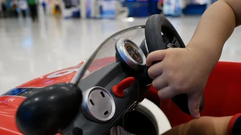 Cute child playing small car in shopping mall department store Stock Footage 94170916