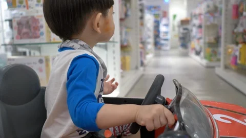 Cute child playing small car in shopping mall department store Stock Footage 109499757