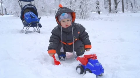 Cute child playing with snow Stock Footage 72699301