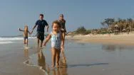 Cute Child Running Along The Beach With Happy Family On Background.slow Motion Stock Footage